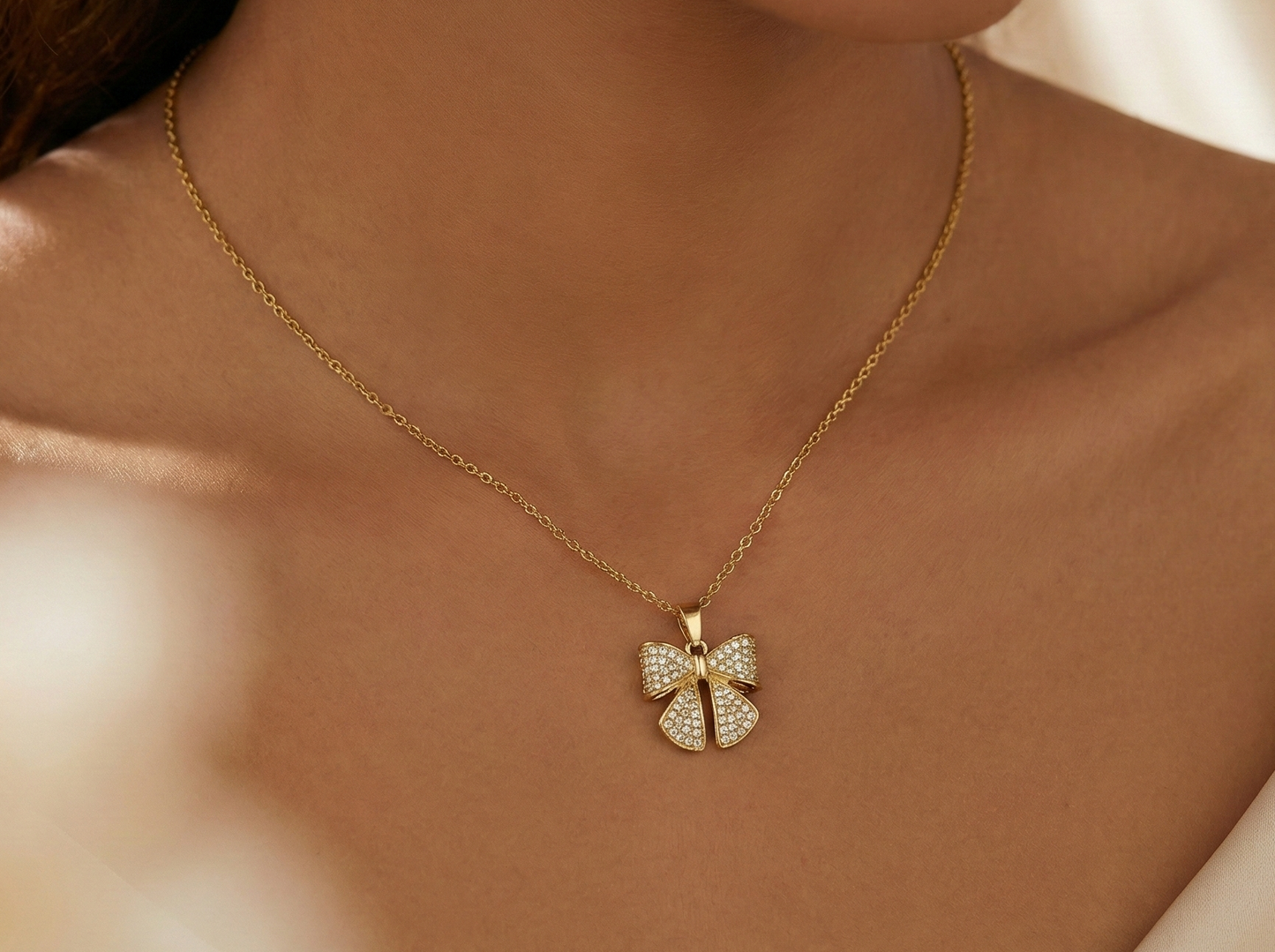 Gold-tone necklace with a bow-shaped  pendant